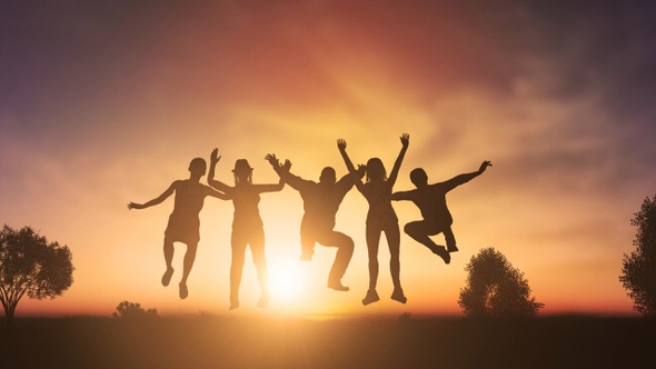 Cheerful People Jumping At Sunset