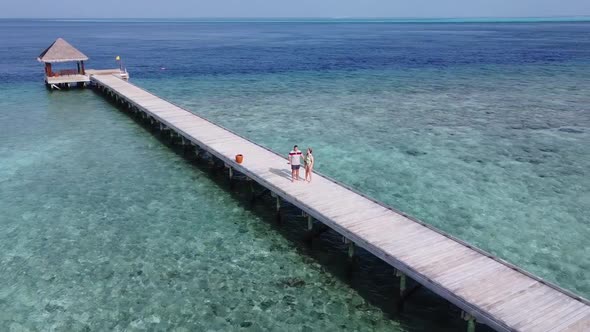 A Man and a Woman Couple Walking on Wooden Decking Bridge Holding Hands