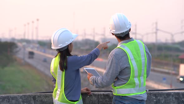 Two civil Engineering working with tablet on bridge highway