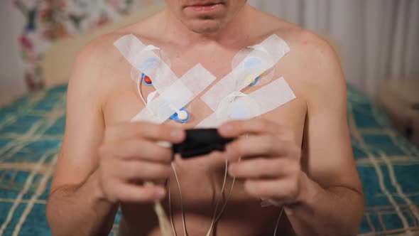 Holter Cardiac Monitor Mounted on Patient's Chest at Home alt