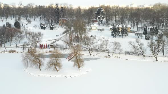 An island on a lake with a bridge in the winter Loshitsky Park.Minsk, Belarus. alt