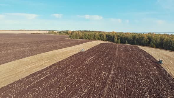 An Autumn Landscape of Fields and Blue Sky - Tractors Plows the Field alt