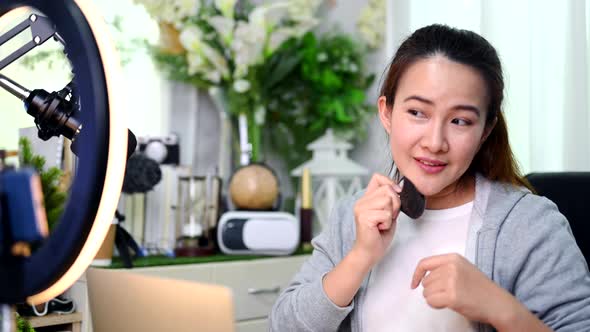Asian Woman blogger or vlogger working online for beauty and makeup. Social media alt