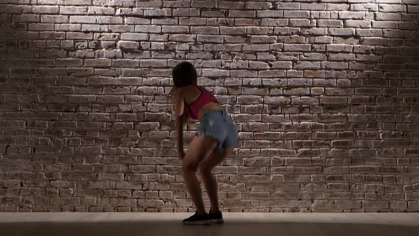 Woman Sexy in Crop Top and Denim Shorts Dance Twerk Against a Brick Wall alt