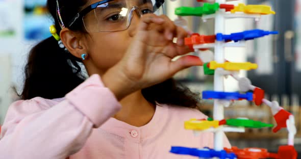 Schoolkid experimenting molecule model in laboratory 4k alt