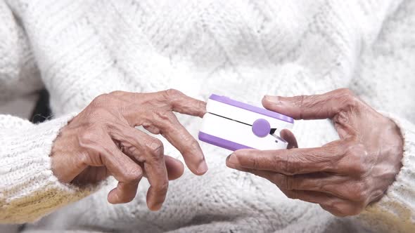 Elderly Women Hand Using Pulse Oximeter alt