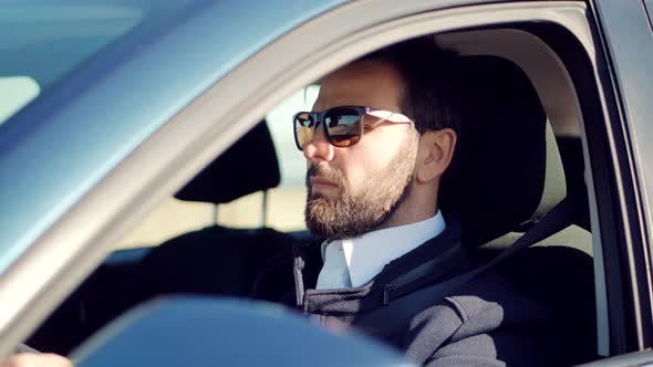 Male Driver Turning Steering Wheel In Car. Man Driving Auto And Using Controls In Car. alt