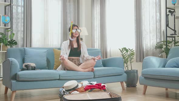 Funny Asian Woman Wearing Scuba Diver Mask Meditating Near Suitcases - Traveling alt
