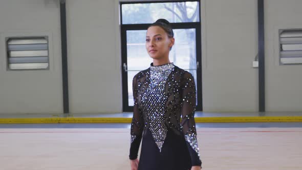 Teenage female gymnast performing at sports hall alt