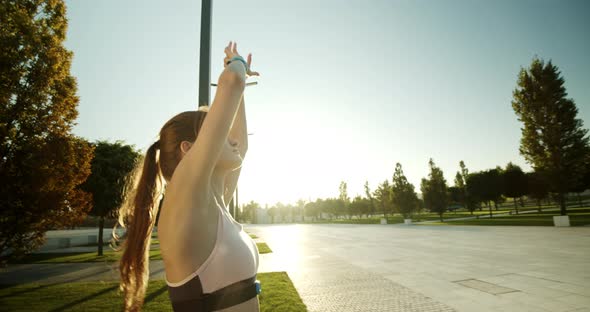 Morning Warmup Before Jogging at Sunrise in a Modern Park