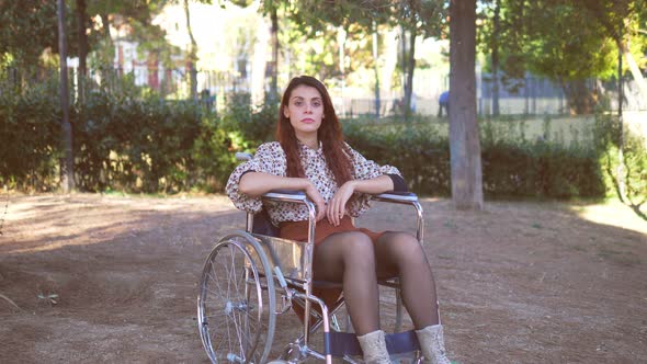 living with disabilities - thoughtful woman with paraplegia alone in the park alt