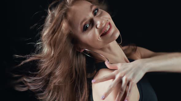 Sexy Woman with Waving Hair Touching Shoulder Posing Isolated on Black alt