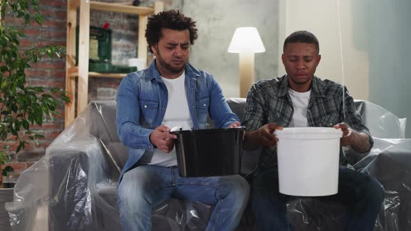 AfricanAmerican Guys Collect Leaking Water Into Basins alt