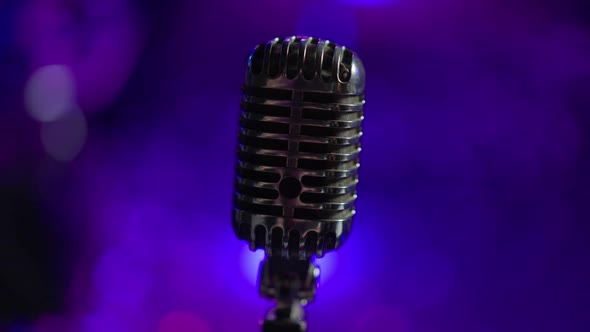 Closeup Black Microphone with Night Club Lights at Background alt