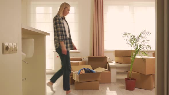 A Young Woman Takes Out a Large Potted Palm Tree From an Old House