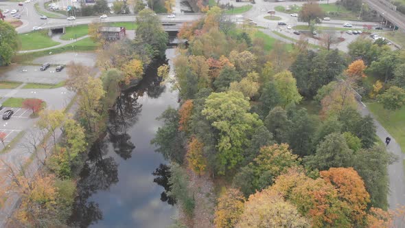 Autumn Trees Along Both Sides of River Slow Pull Back Aerial