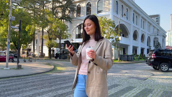 Woman With Coffee and Smartphone in the City