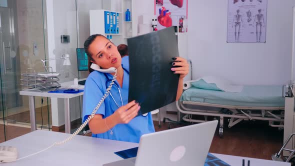 Nurse Receptionist Answering at Hospital Call Holding Xray alt