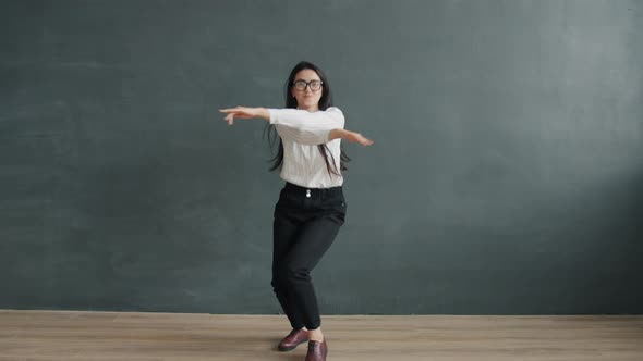 Slow Motion Portrait of Attractive Asian Girl in Formal Clothing Dancing Alone on Grey Color alt