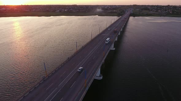 Aerial Shot of a Lanky Bridge Over the Dnipro at a Dreamy Sunset in Summer alt