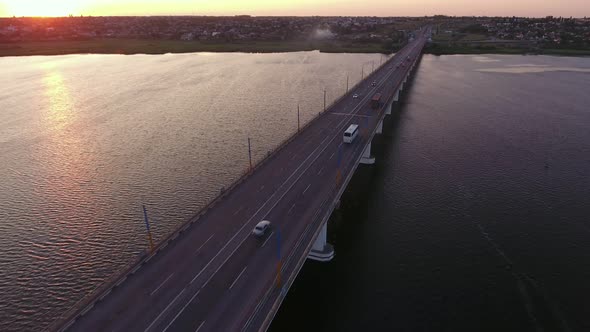 Aerial Shot of a Lanky Bridge Over the Dnipro at a Dreamy Sunset in Summer