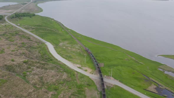 A Drone View of a Freight Train Driven By a Diesel Locomotive on a Railroad alt