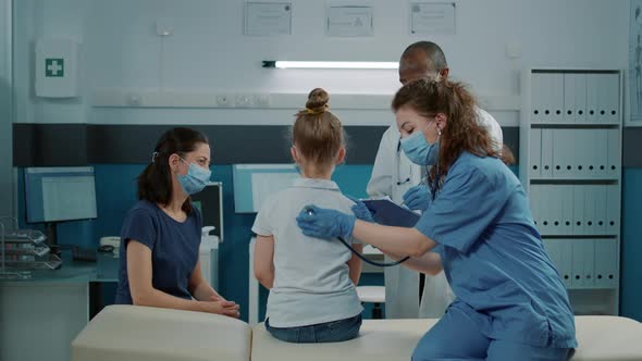 Woman Nurse Using Stethoscope on Small Kid to Do Pulse Exam alt