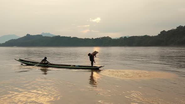 Fisherman Throwing The Nets On Boat In Mekong River alt