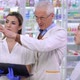 Expert Senior Pharmacist Talking with Young Caucasian and Asian Employees in Pharmacy Explaining - VideoHive Item for Sale