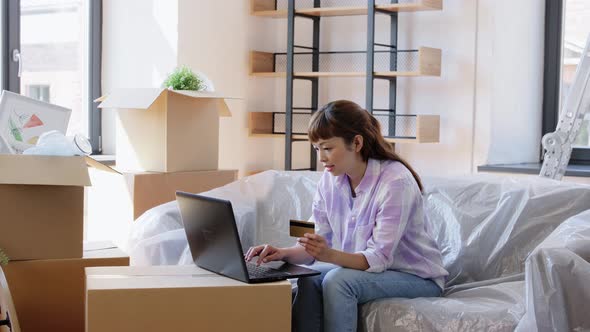 Woman with Laptop and Credit Card at New Home alt