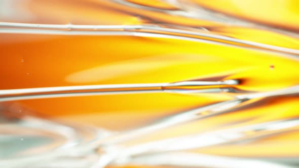 Super Slow Motion Shot of Flowing Oil Liquid on Golden Background at 1000Fps. alt