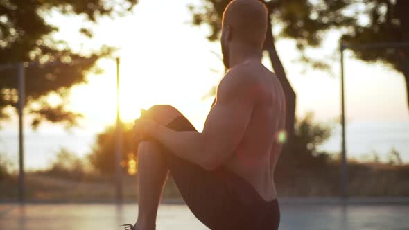 Sporty Strong Afro American Guy in Black Shorts Putting Up and Stretching Legs Making Workout on alt