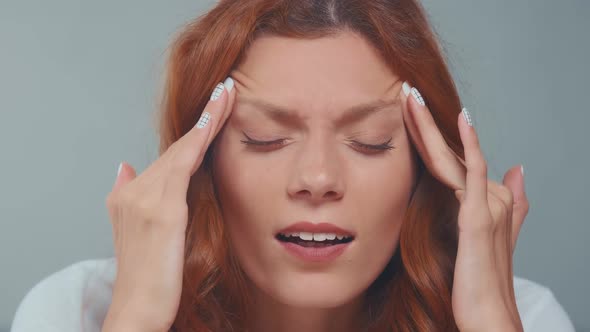 Close Up Redhead Woman with Closed Eyes Covered Face in Hands Feeling Pain alt