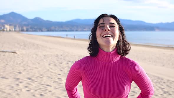 Young Woman Smiling on the Beach Against the Background of the Sea