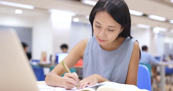 Woman Working on Homework in Library 