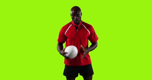 Professional Rugby Player Standing and Pointing with A Ball on Green Background alt