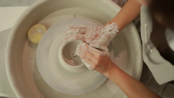 Woman Modelling Clay Bowl on Pottery Wheel