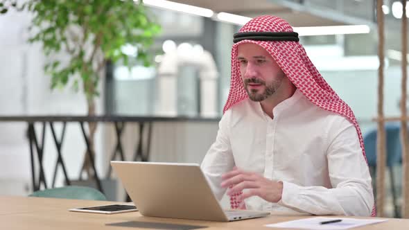 Excited Arab Businessman Celebrating Success on Laptop alt