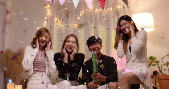 Group of Asian friend having enjoy with confetti at night party. alt