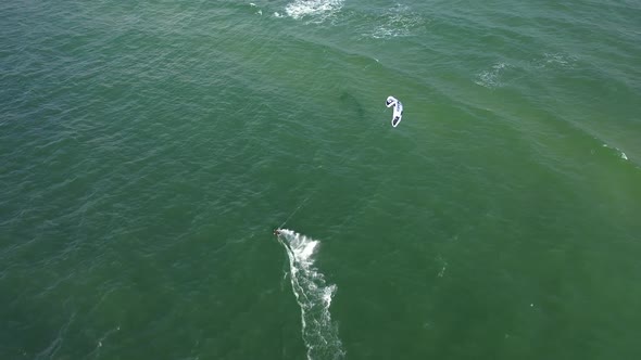 AERIAL: High Altitude Drone Shot of Surfer Riding Waves in Baltic Sea