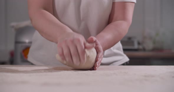 Female Hands Knead and Toss Dough on Kitchen