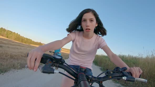 POV of a young girl enjoying a bicycle ride on the rural countryside alt