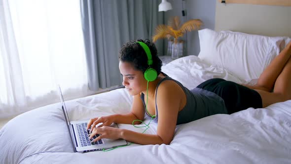 Woman working on laptop while listening to music alt