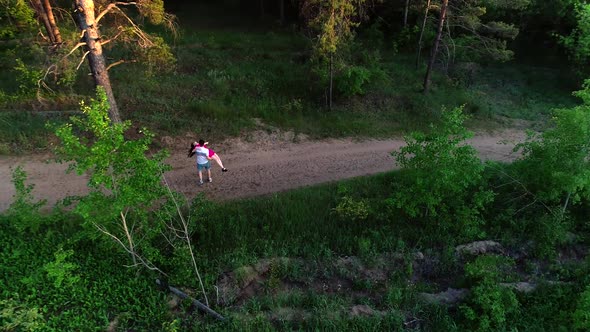 Top View of a Couple in Love Running Through the Woods