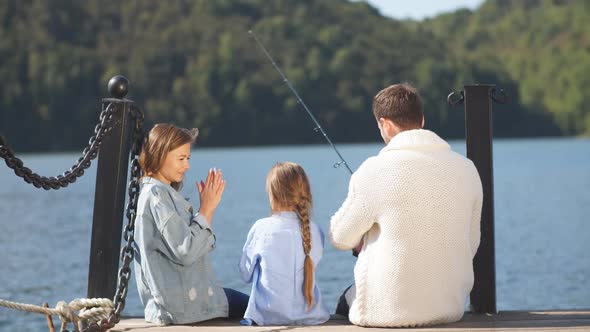 Family Sit on Pier in Autumn Day. Fall Family Portrait alt