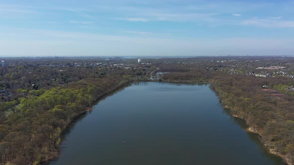 An aerial view of a reflective lake during the day. The horizon is visible from this height, as the alt