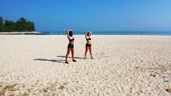 Girls tanning on relaxing shore beach adventure by blue lagoon with bright sandy background of Thail alt