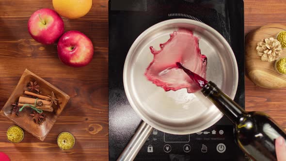 Woman Cooking Mulled Wine Gluhwein with Apples and Oranges Recipe alt
