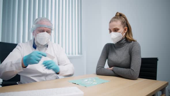 Modern Private Clinic Adult Man Doctor in a Protective Uniform Makes an Express Test for the alt