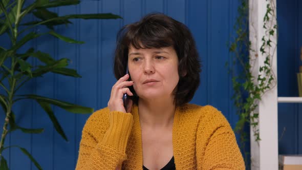 Middle Aged Businesswoman Talking on Smartphone at Home